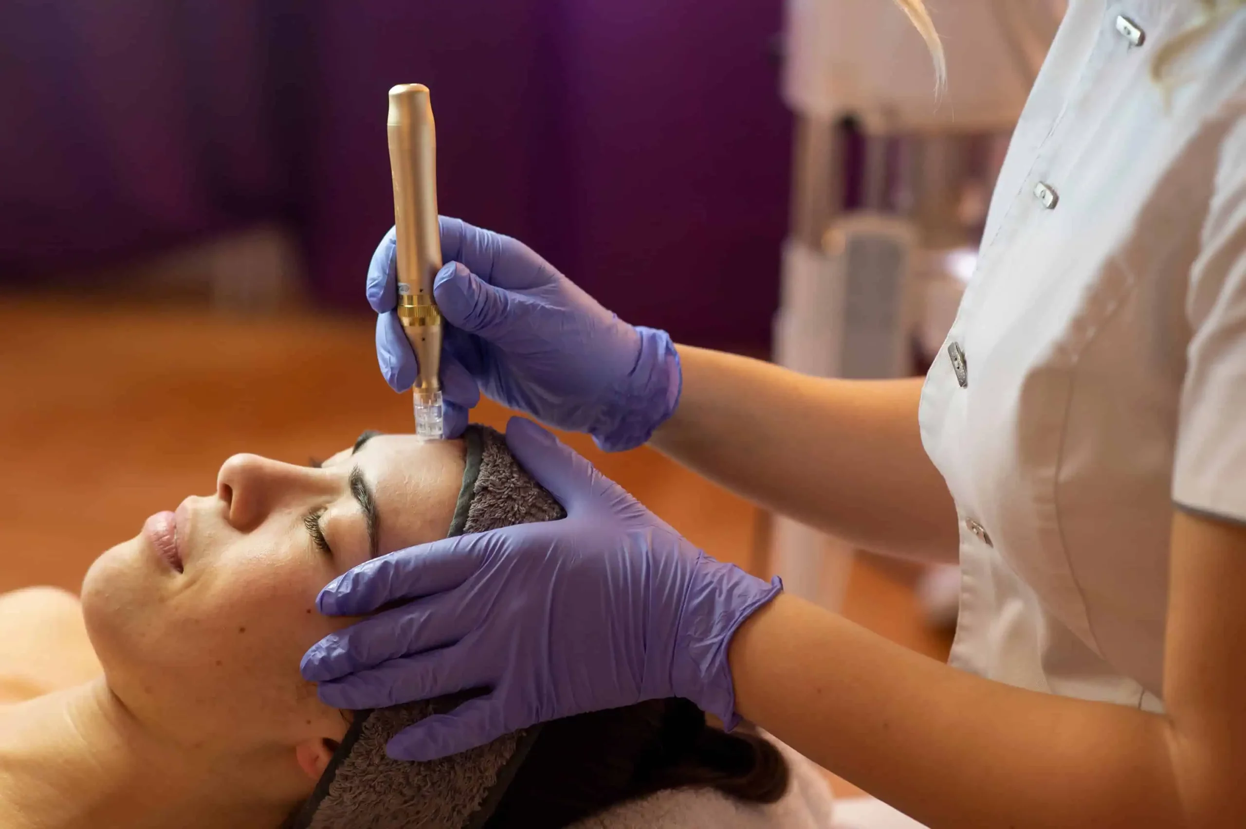 A clinician performing a facial skin-tightening treatment with a handheld device in Mission Viejo